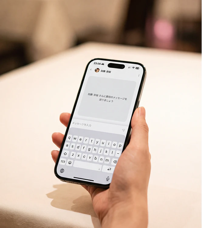 ゲストチャットの画面を開いたスマートフォンを手に持つ様子